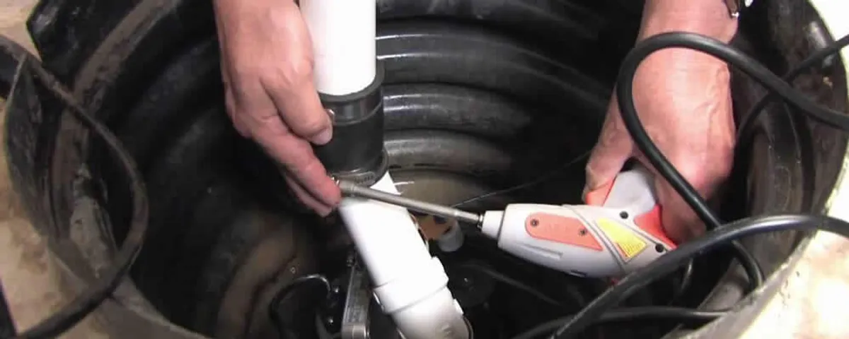 Sump pump installation technician connecting PVC discharge piping in Escondido, CA